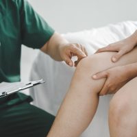 patient is consulting a therapist and explaining with injured leg or knee after the accident and explain to her the diagnosis of the problem in clinic, Sport exercise injuries.