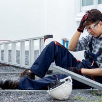 Construction foreman injured by broken head while working at building site. Male worker head was hit by steel beam and fall from the ladder. Accident and Injury at work. Safety first concept.