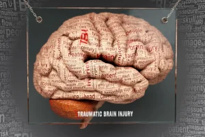 Illustration of a human brain composed of words related to traumatic brain injury. Words like "memory," "trauma," and "patient" are visible. The tone is clinical.